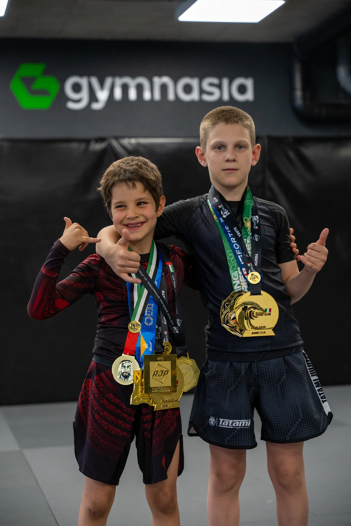 Young grapplers celebrating medals after a camp competition